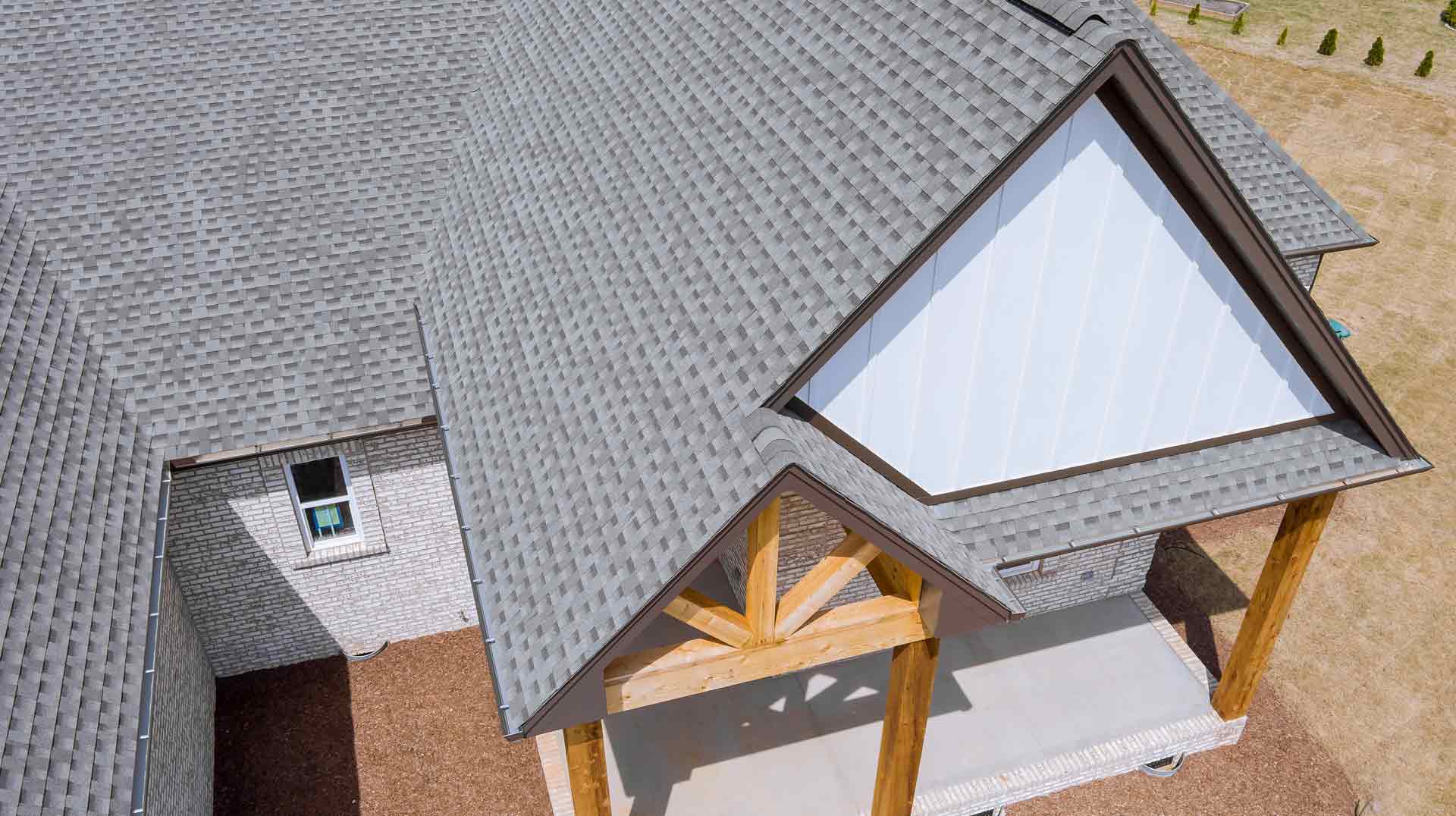 Edge of roof shingles on top of the house asphalt tiles the roof