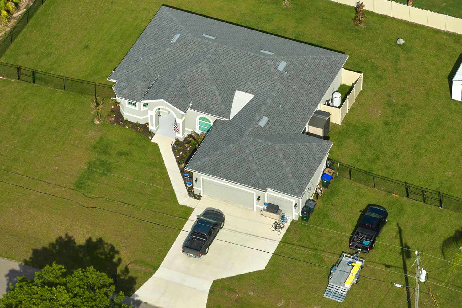 Aerial view of a light gray home with gray asphalt shingles