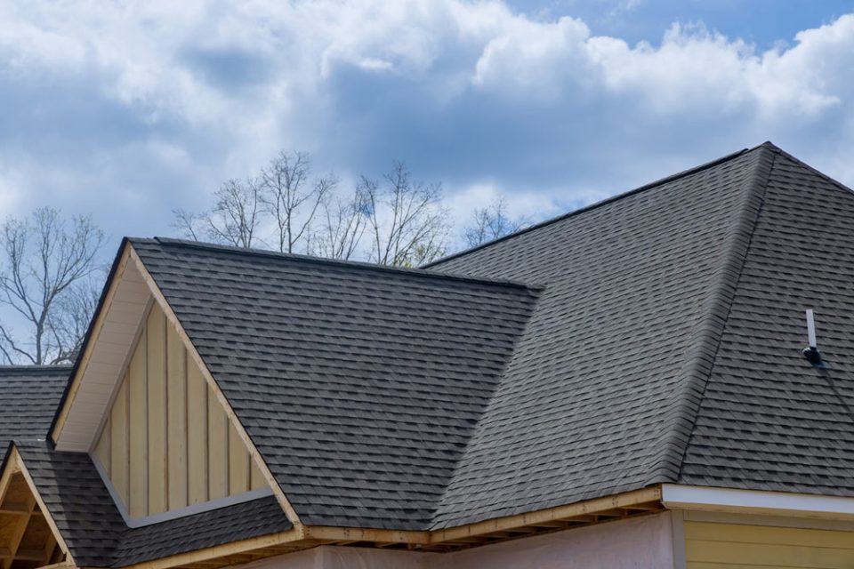 Close up view of a home with a gray asphalt roof