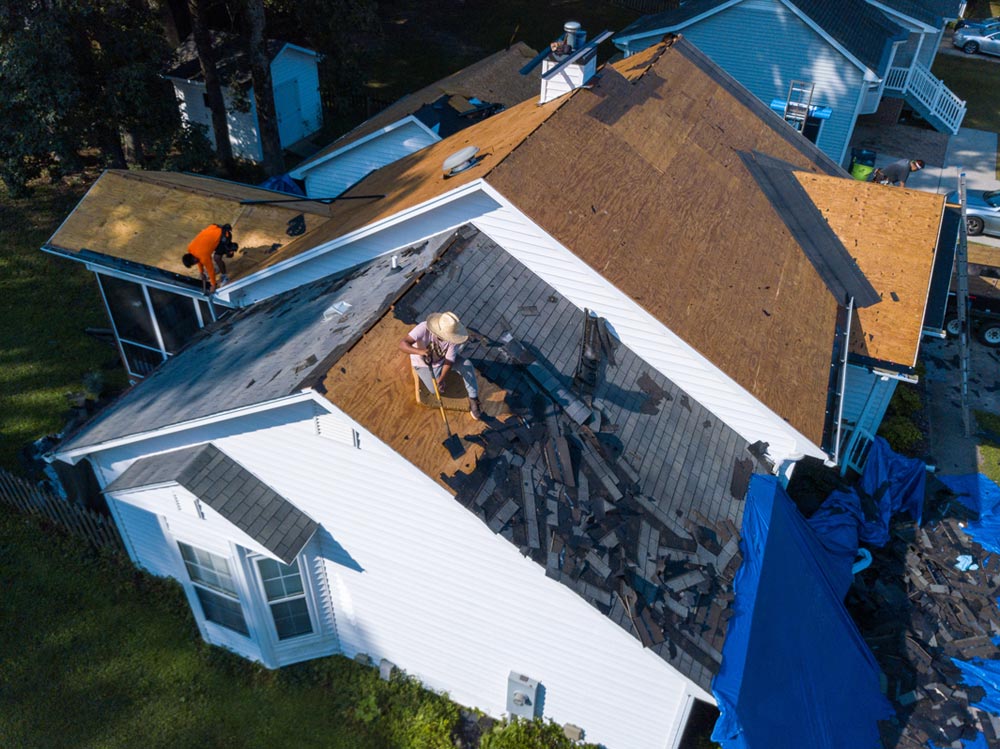 Aerial view of roofers tearing down old roof