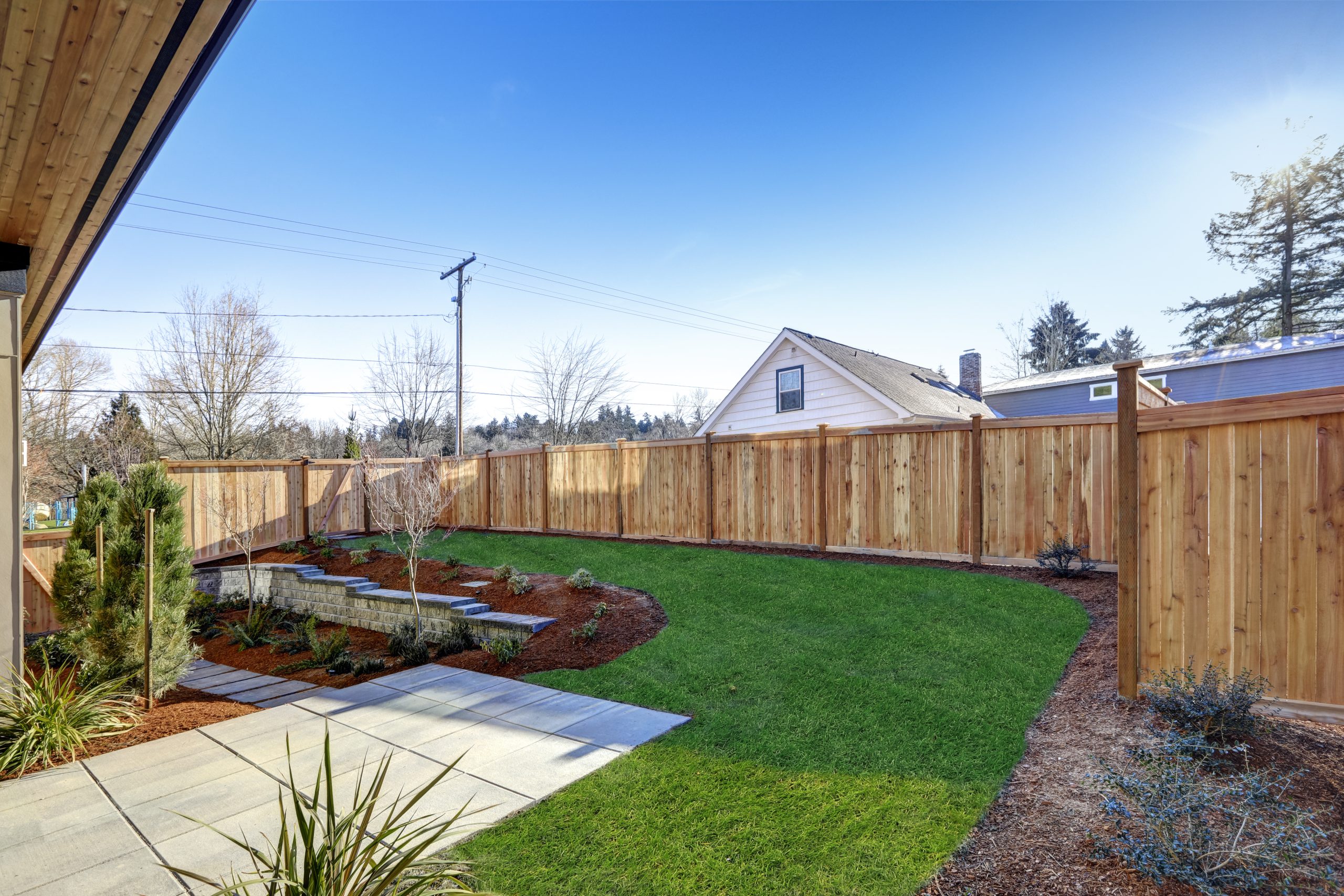 Sloped backyard surrounded by wooden fence Luxury New construction